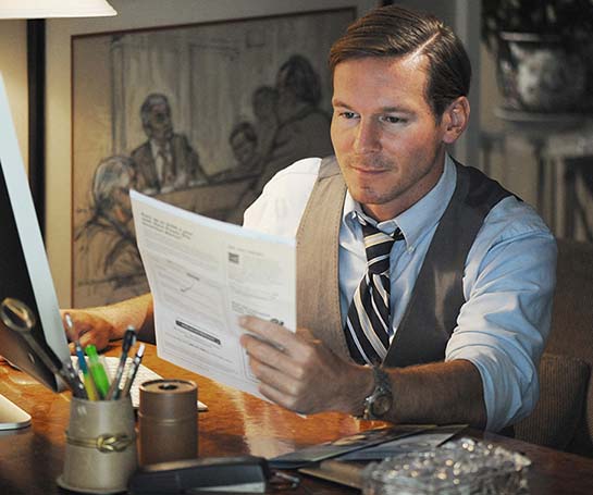 Man sitting at his desk overlooking his paper bil