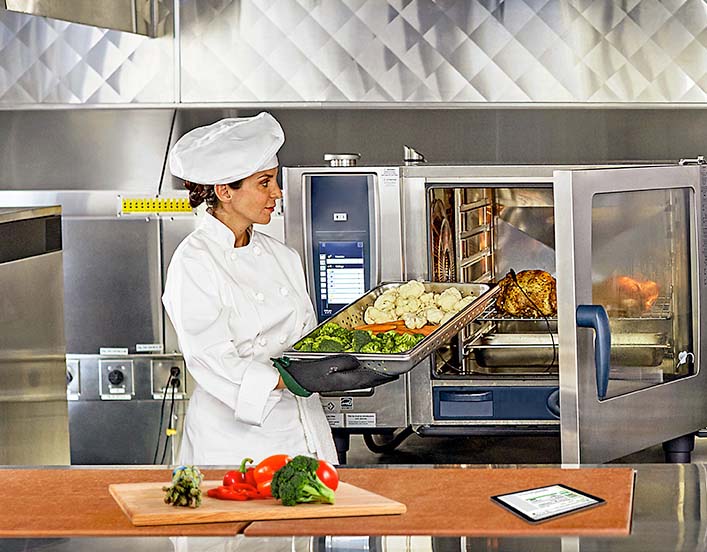 woman cooking in industrial kitchen.